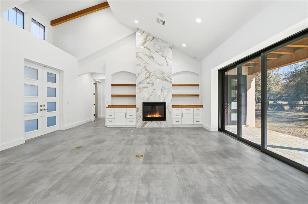 16728 Bearle Road Orlando, FL 32828 - Photo 11 of 72 a view of an empty room with a fireplace and a large window