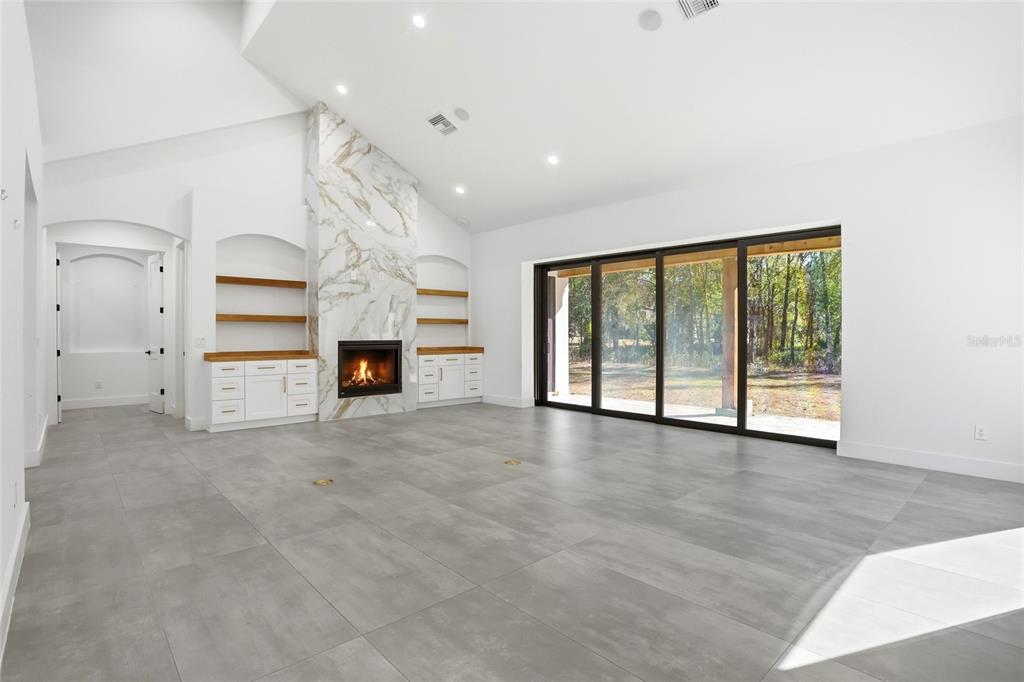 16728 Bearle Road Orlando, FL 32828 - Photo 10 of 72 an empty room with fireplace cabinet and windows