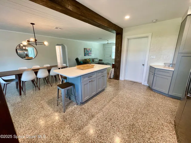 a dining hall with granite countertop a sink and white cabinets