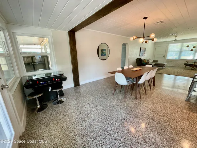 a dining room with a wooden table and chairs
