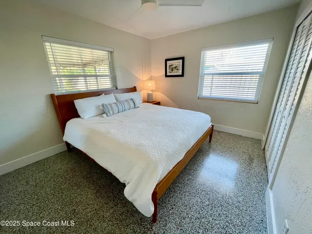 a bedroom with two beds and window