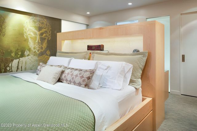 a large bed sitting in a bedroom next to a window