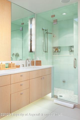 a bathroom with a double vanity sink mirror and shower