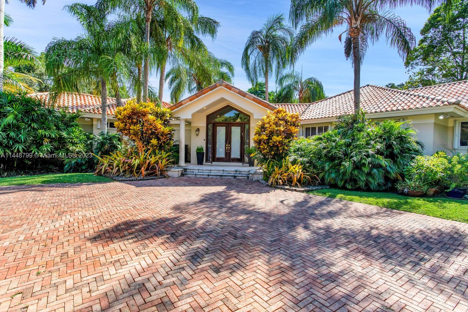 9718 Southwest 58th Court Pinecrest, FL 33156 - Photo 1 of 35 a view of a house with a yard and palm trees