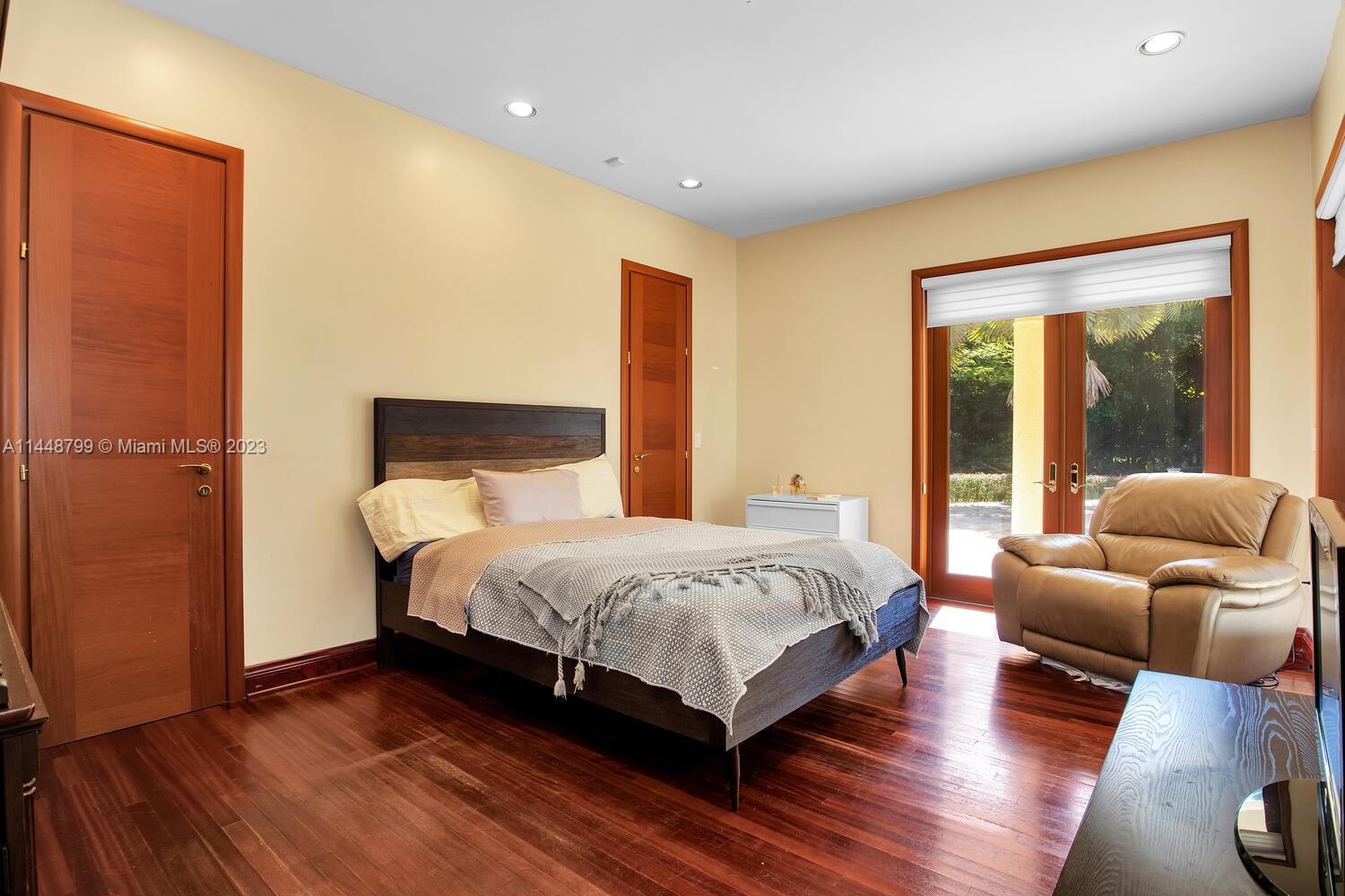 9718 Southwest 58th Court Pinecrest, FL 33156 - Photo 21 of 35 a bedroom with a bed and wooden floor