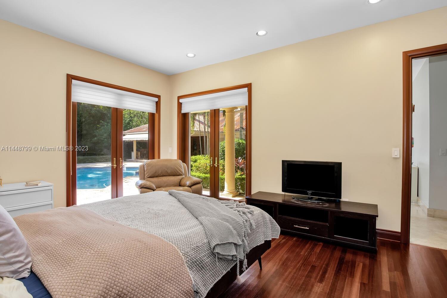 9718 Southwest 58th Court Pinecrest, FL 33156 - Photo 22 of 35 a bedroom with a bed and a flat screen tv