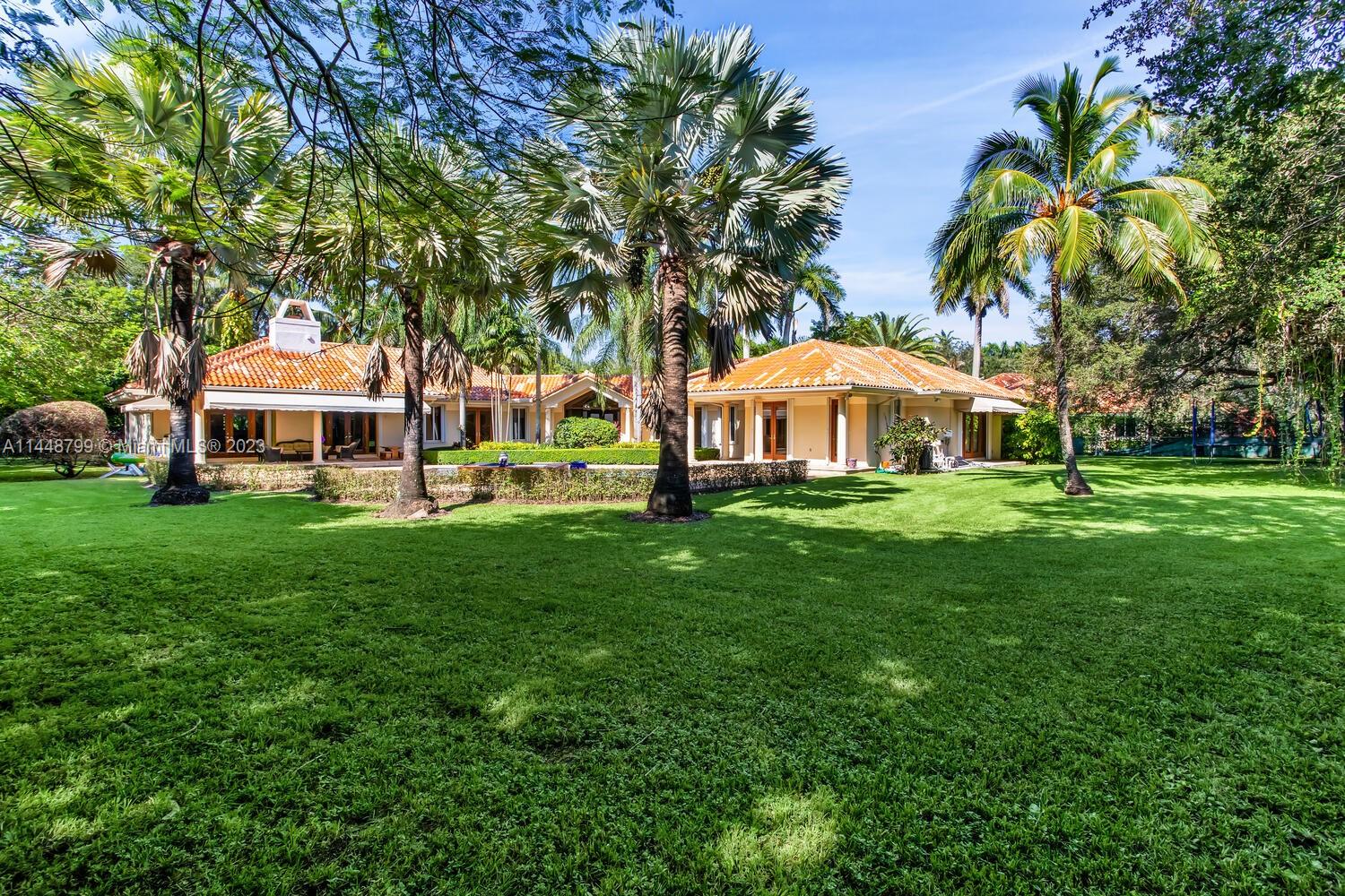 9718 Southwest 58th Court Pinecrest, FL 33156 - Photo 30 of 35 a front view of house with yard and green space