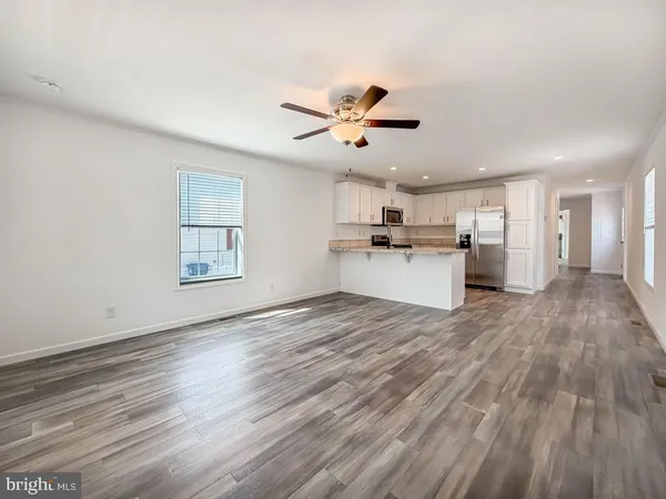 a view of a kitchen with a wooden floor and a ceiling fan