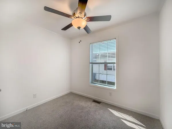 an empty room with a window and a fan