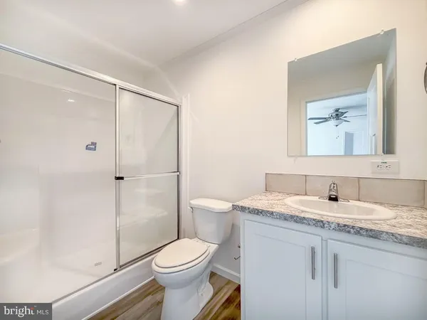 a bathroom with a granite countertop sink toilet and shower