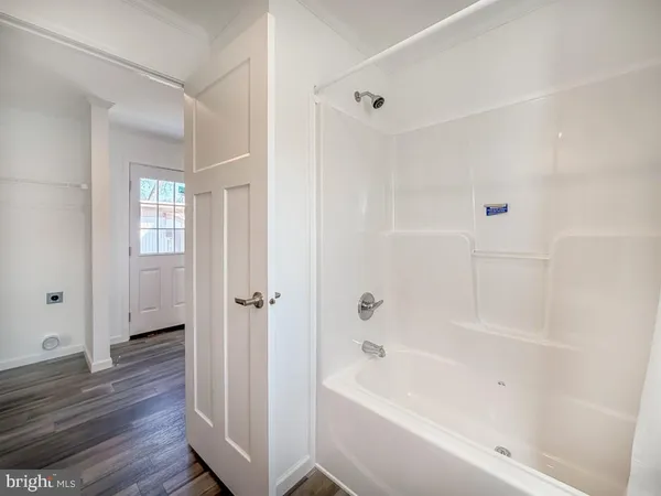 a bathroom with a bathtub shower and a sink