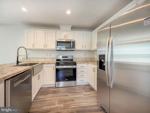a kitchen with kitchen island granite countertop a stove sink and refrigerator