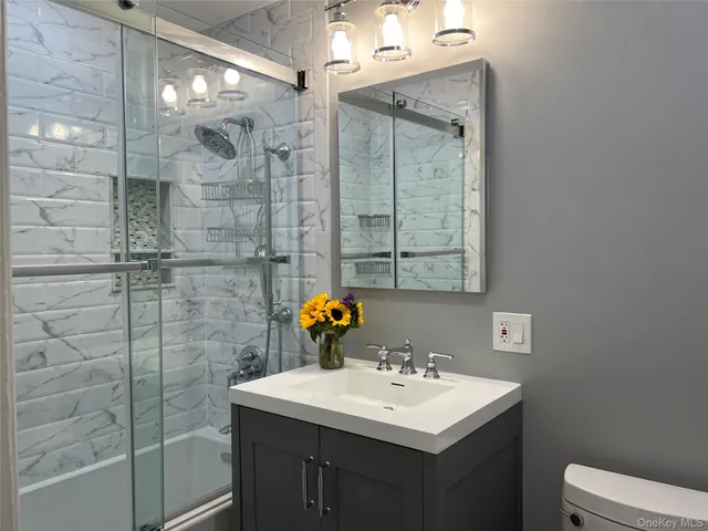 a bathroom with a sink shower and a mirror