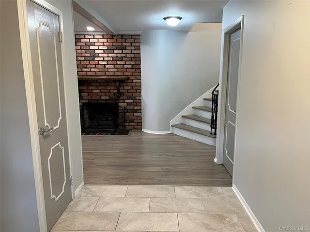 an empty room with wooden floor a fireplace and windows