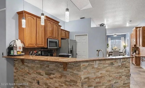 a view of a kitchen with granite countertop a sink and a counter top space