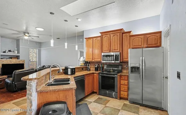 a kitchen with stainless steel appliances granite countertop a stove refrigerator sink and dishwasher