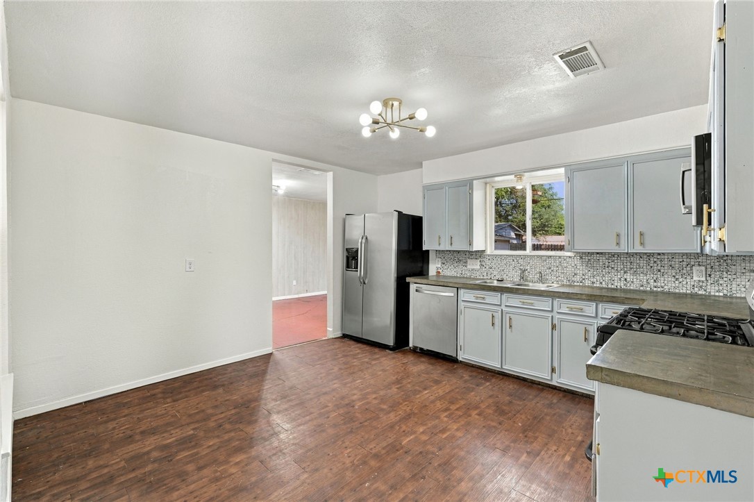 904 Kirk Street Taylor, TX 76574 - Photo 9 of 25 Kitchen showing freshly painted cabinets & updated hardware.