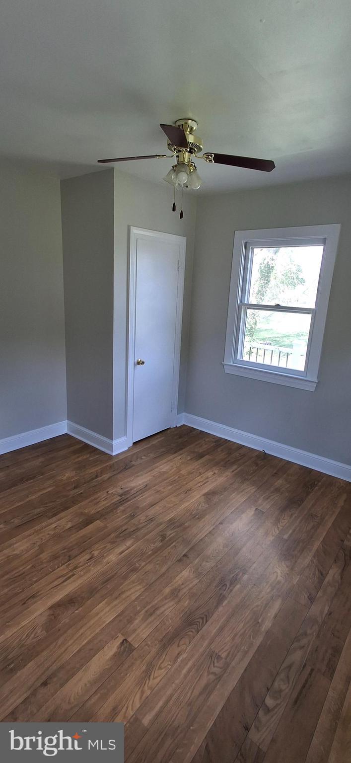 714 Crosby Road Front Royal, VA 22630 - Photo 10 of 37 an empty room with wooden floor chandelier fan and windows