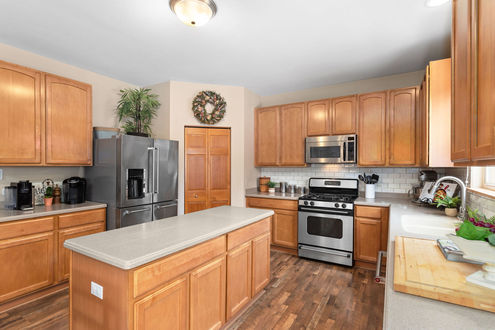 1476 Wildmeadow Road Round Lake, IL 60073 - Photo 9 of 37 a kitchen with stainless steel appliances granite countertop a stove top oven a sink and dishwasher a refrigerator with wooden floor