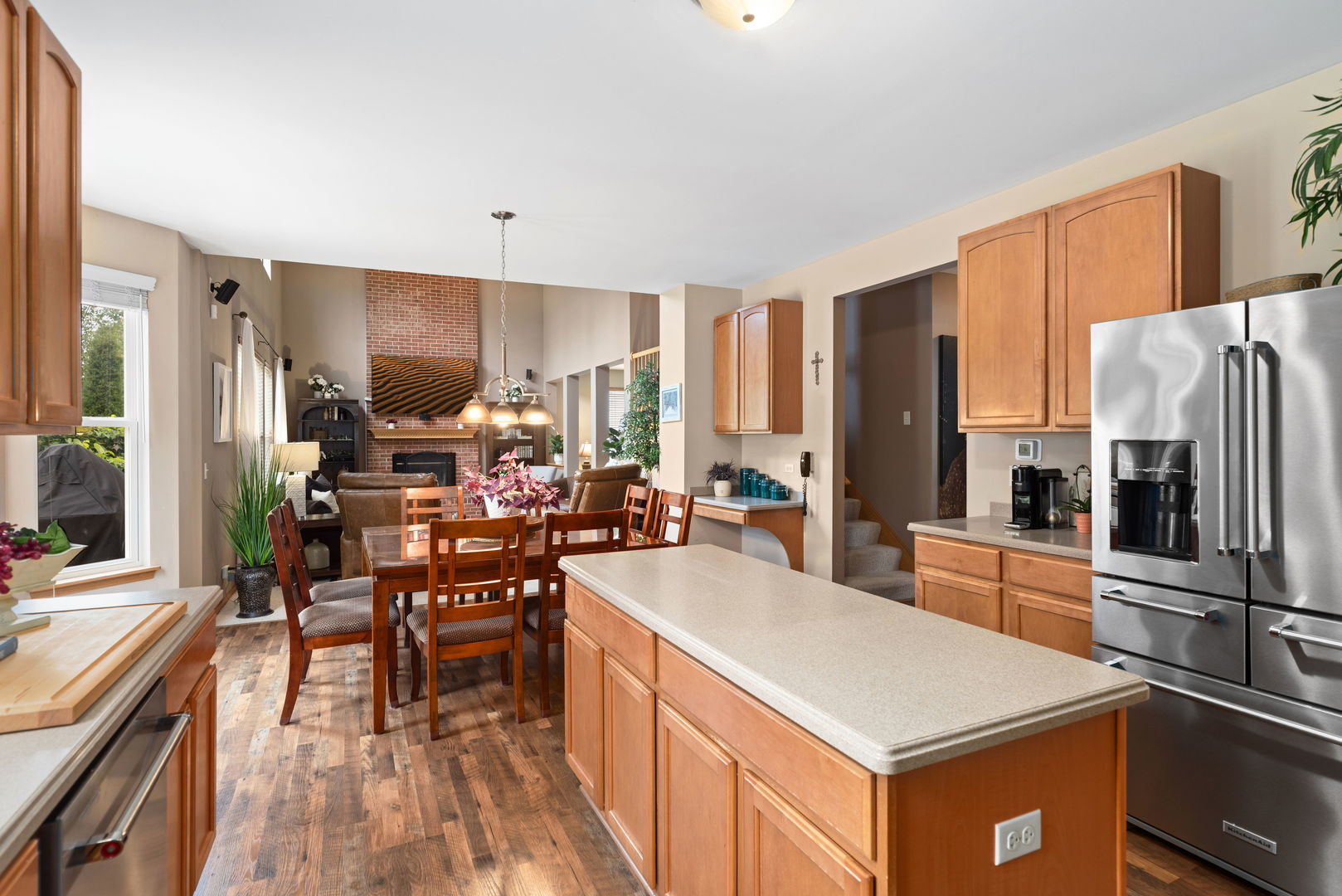 1476 Wildmeadow Road Round Lake, IL 60073 - Photo 10 of 37 a kitchen with a refrigerator a stove and a dining table with wooden floor
