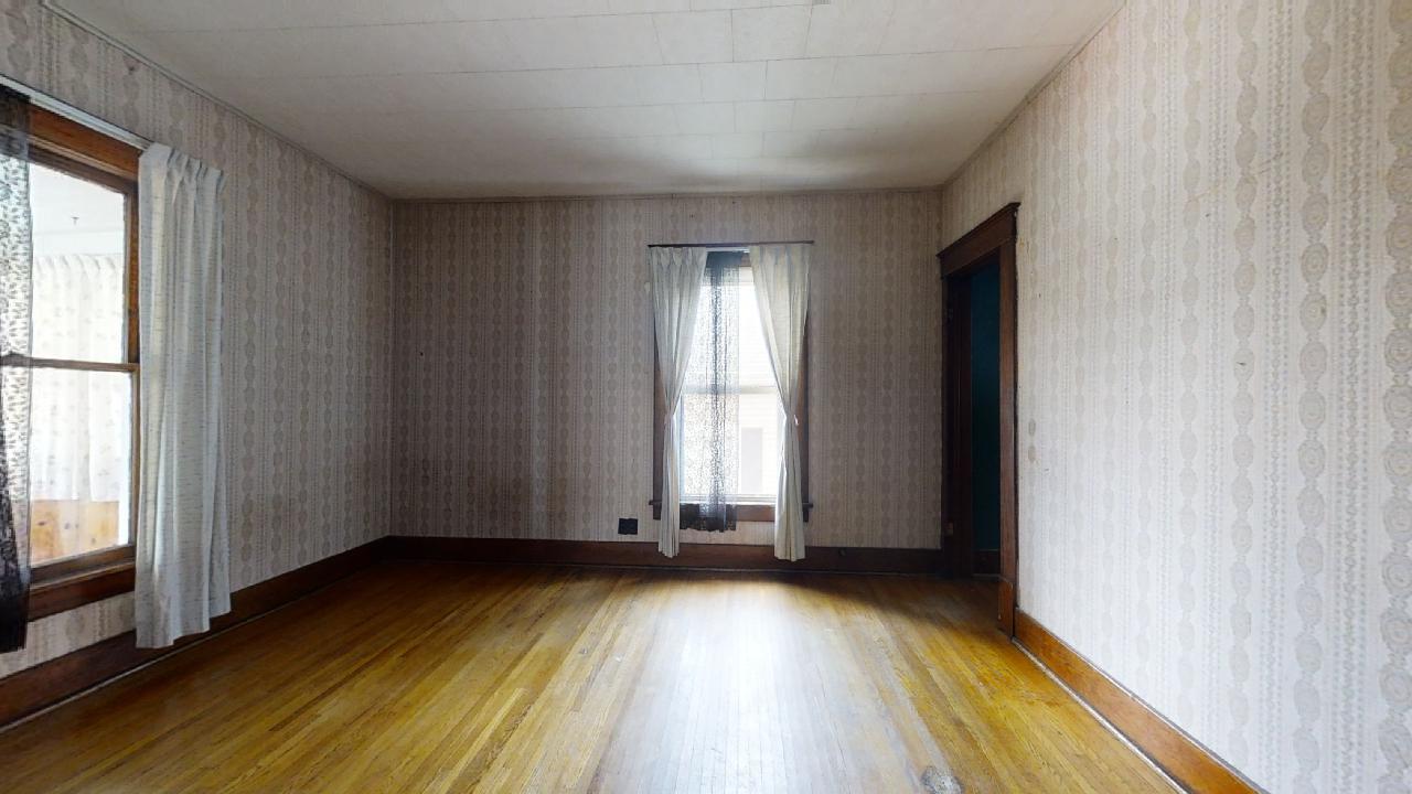208 East State Street Fairmount, IL 61841 - Photo 19 of 42 an empty room with wooden floor and windows