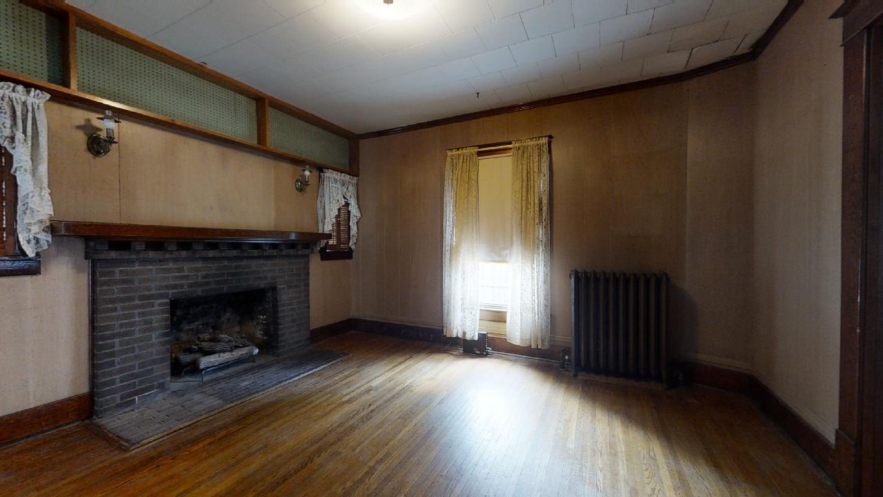 208 East State Street Fairmount, IL 61841 - Photo 10 of 42 a view of an empty room with wooden floor fireplace and a window