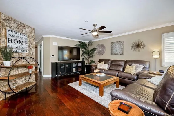 a living room with furniture a flat screen tv and a table