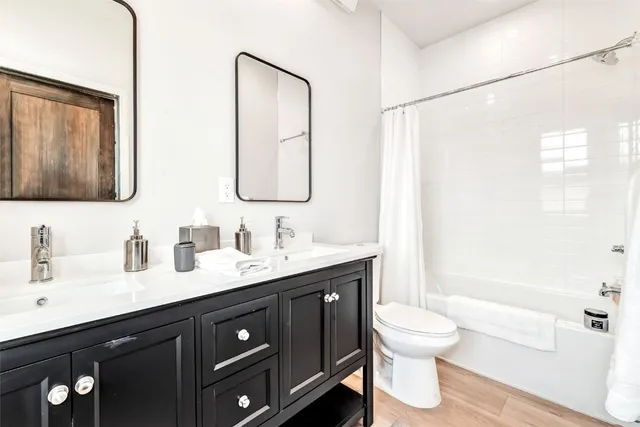 a bathroom with a double vanity sink toilet and a mirror