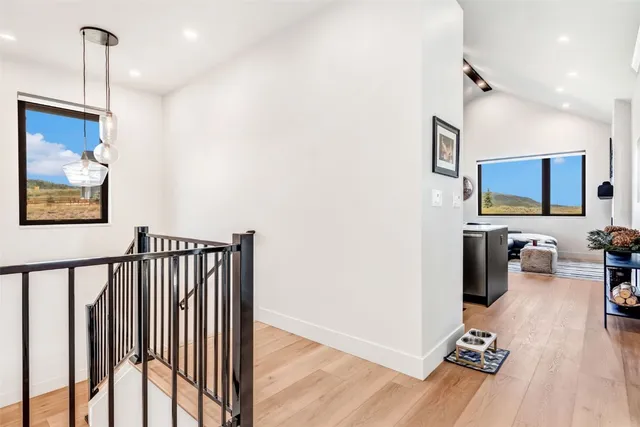 a view of a hallway with wooden floor and furniture