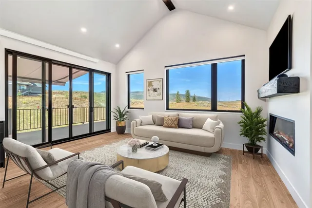 a living room with furniture large windows and a flat screen tv