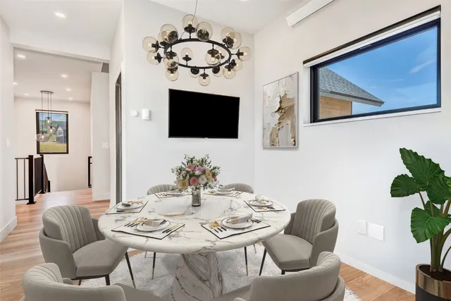 a dining room with furniture a potted plant and a flat screen tv