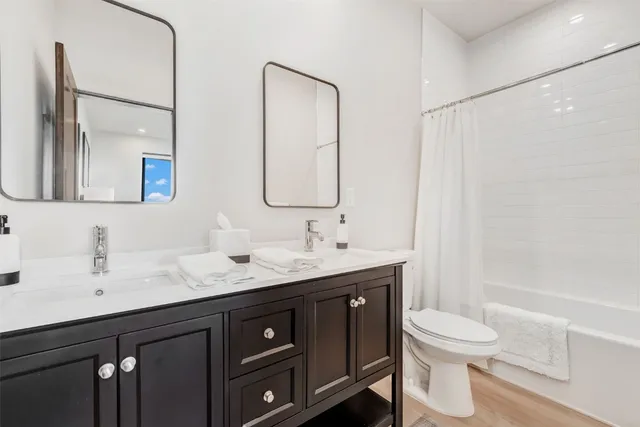a bathroom with a granite countertop sink toilet a mirror and shower