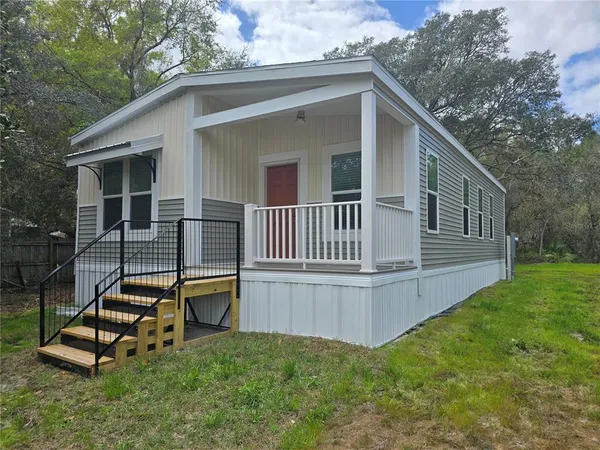 a view of a small house with a yard