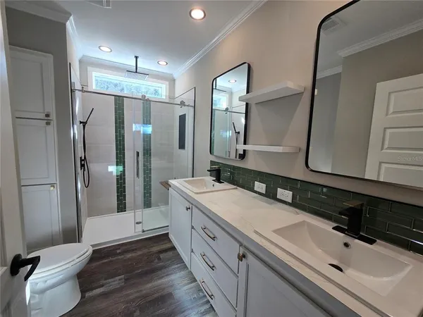 a bathroom with a double vanity sink a toilet and a mirror