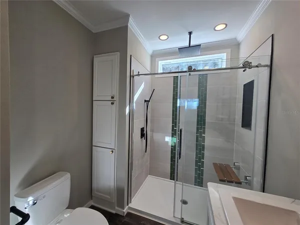 a bathroom with a glass shower door and a toilet