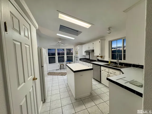a kitchen with a sink a stove top oven and cabinetry