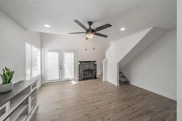 a view of an empty room with a fireplace and a window