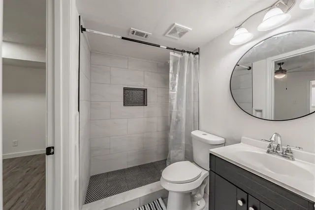 a bathroom with a sink toilet and shower