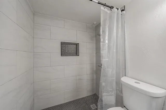 a bathroom with a toilet and shower