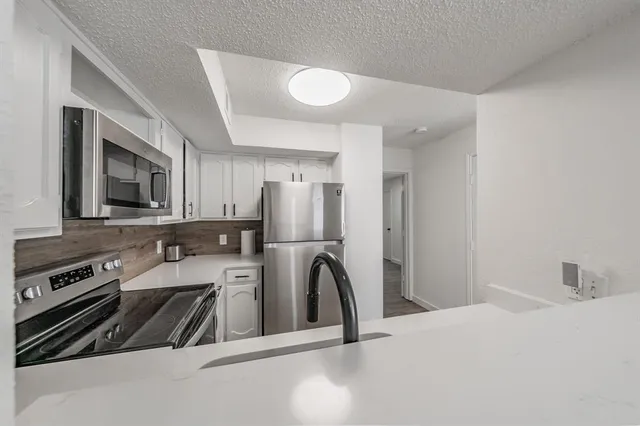 a kitchen with a refrigerator a stove a sink and a microwave