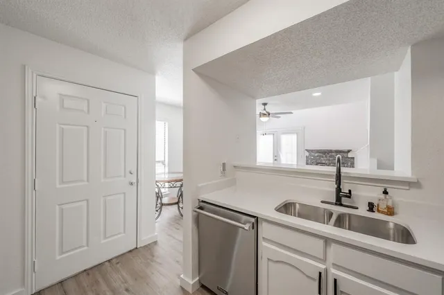 a kitchen with a sink cabinets and wooden floor