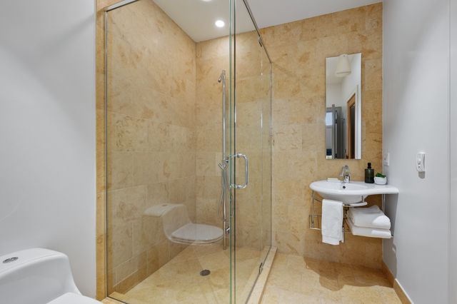 a bathroom with a sink a toilet and shower