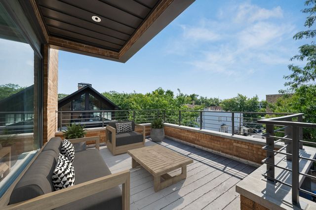 a view of a roof deck with couches and wooden floor