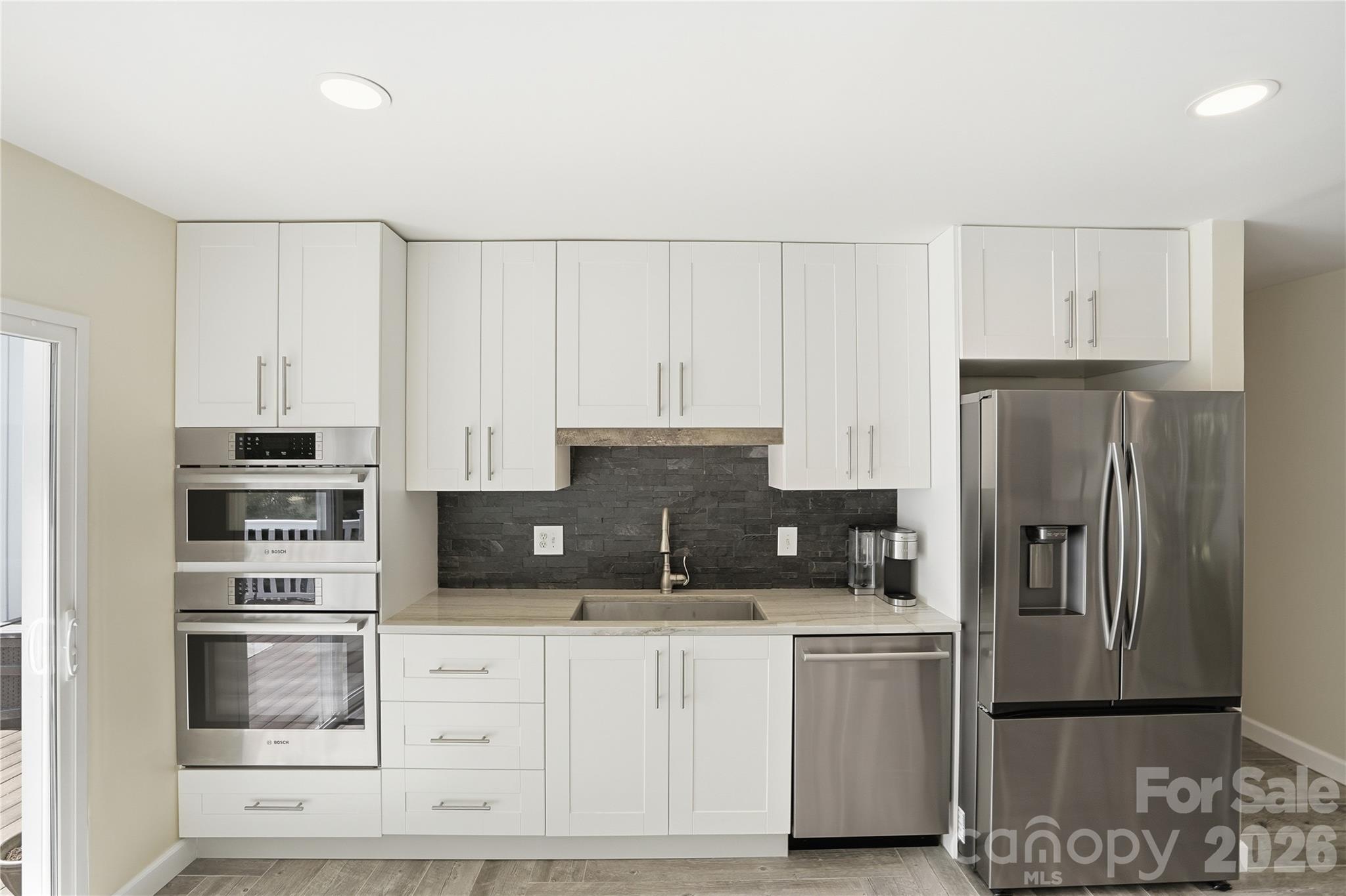 19011 Kailua Circle Tega Cay, SC 29708 - Photo 10 of 48 a kitchen with kitchen island a refrigerator sink and cabinets