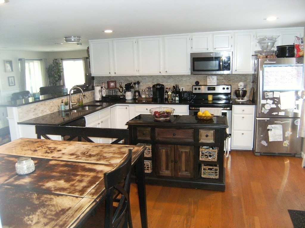 44 Littleville Road Huntington, MA 01050 - Photo 8 of 29 a kitchen with stainless steel appliances granite countertop a stove top oven a sink a refrigerator white cabinets and wooden floor