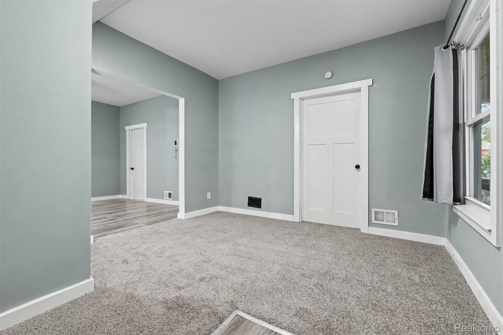 8397 Lane Street Detroit, MI 48209 - Photo 2 of 41 Carpeted room with light blue walls, white trim, and a white interior door