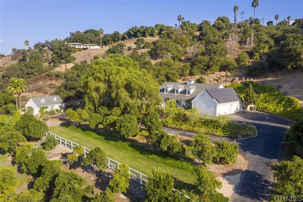an aerial view of residential houses with outdoor space and trees all around