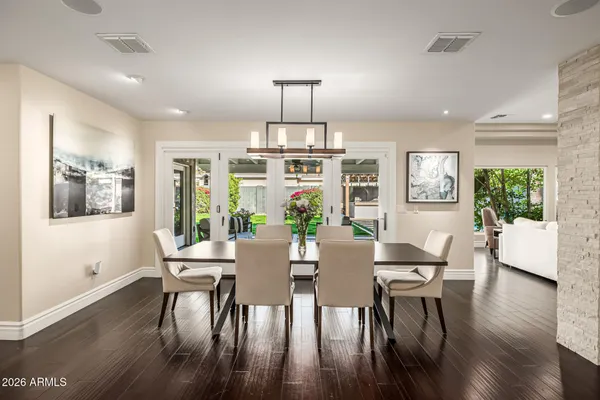 a kitchen with stainless steel appliances granite countertop a stove a sink a refrigerator and wooden floor