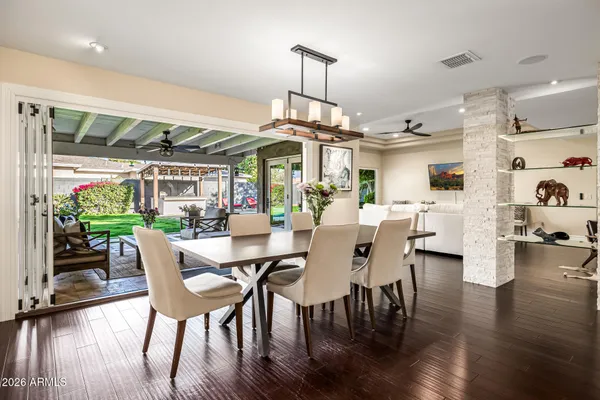 a kitchen with stainless steel appliances kitchen island granite countertop a stove a sink a refrigerator and white cabinets with wooden floor