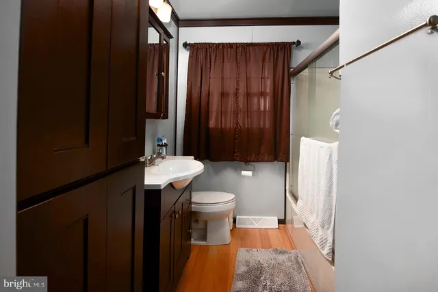 a bathroom with a sink a toilet and shower curtain